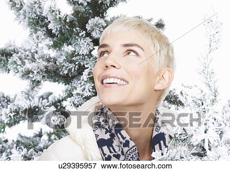 Stock Photo - Woman smiling, snowy christmas trees. Fotosearch