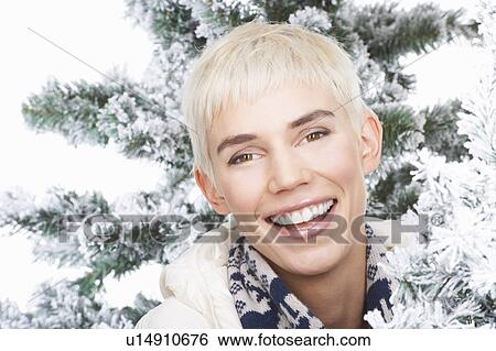 Stock Photograph - Woman smiling, snowy trees around. Fotosearch