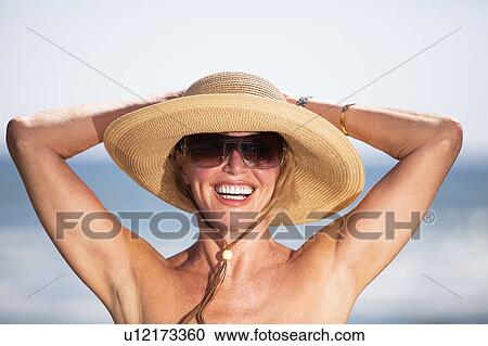 Stock Image - Woman standing by beach. Fotosearch