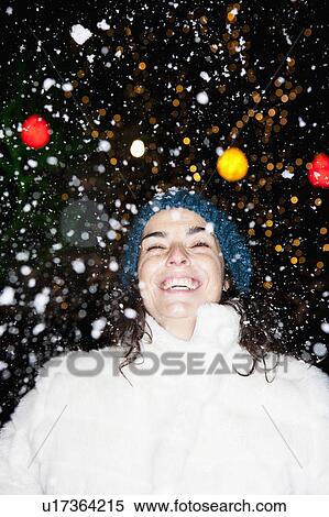 Stock Photography - Woman standing in snowfall. Fotosearch