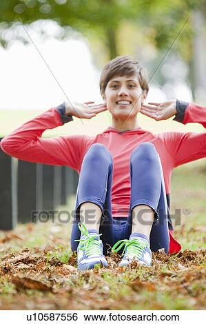 Woman stretching in park before workout View Large Photo Image Stock Photograph - Woman stretching in park before workout. Fotosearch