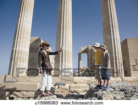 Stock Image - Woman taking photo of two boys. Fotosearch