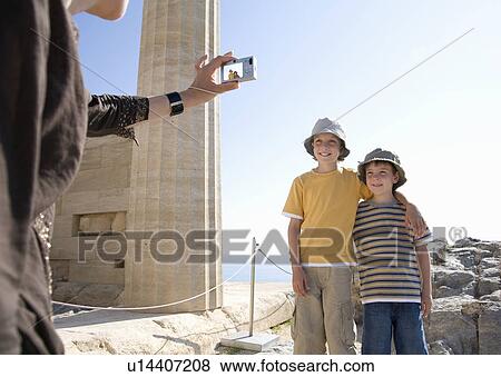Woman taking photo of two boys View Large Photo Image Stock Photo - Woman taking photo of two boys. Fotosearch