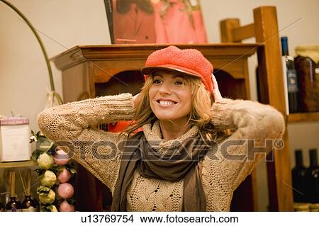 Picture - Woman trying on a hat. Fotosearch