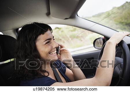 Woman using cellphone while driving View Large Photo Image Stock Photography - Woman using cellphone while driving. Fotosearch