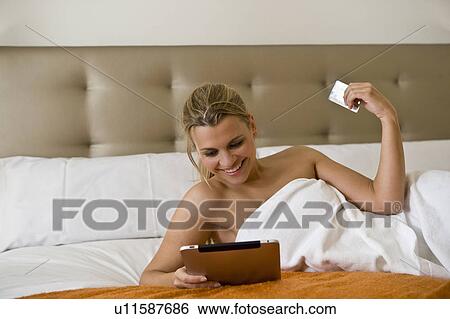Stock Photograph - Woman using tablet computer for shopping. Fotosearch