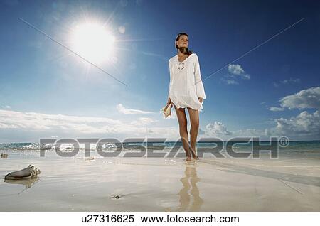Stock Photography - Woman walking on beach. Fotosearch