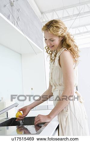 Stock Photo - Woman washing lemon. Fotosearch