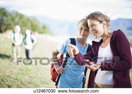 Woman watching a compass with boy View Large Photo Image Stock Image - Woman watching a compass with boy. Fotosearch