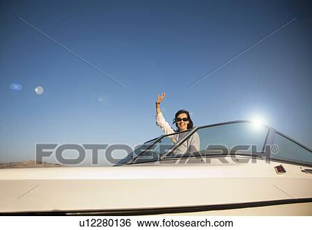 Woman waving on speedboat View Large Photo Image Stock Photograph - Woman waving on speedboat. Fotosearch