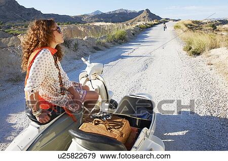 Stock Photo - Woman with broken down motorbike. Fotosearch