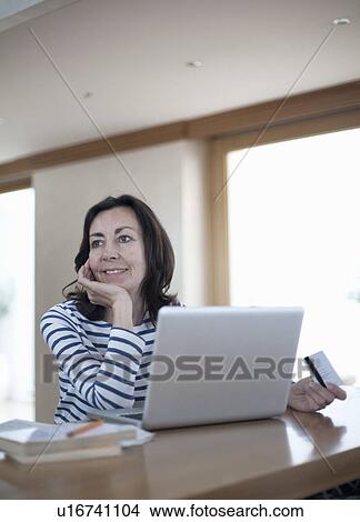 Picture - Woman with credit card and laptop. Fotosearch