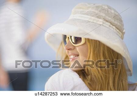 Stock Image - Woman with hat and sunglasses. Fotosearch