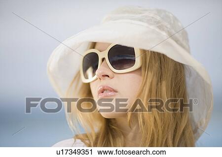 Stock Image - Woman with hat and sunglasses. Fotosearch