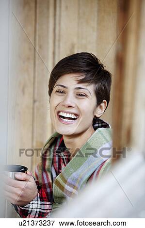 Stock Photo - Woman with hot drink in hut. Fotosearch