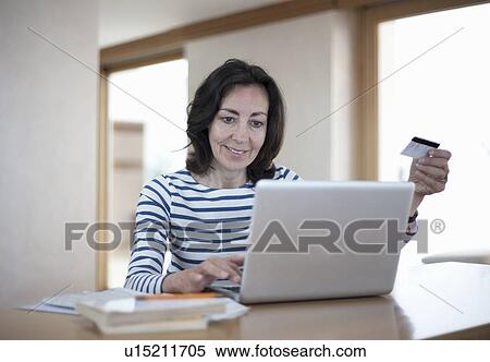 Stock Photography - Woman with laptop and credit card. Fotosearch