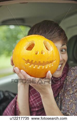 Stock Photography - Woman with pumpkin on Halloween. Fotosearch