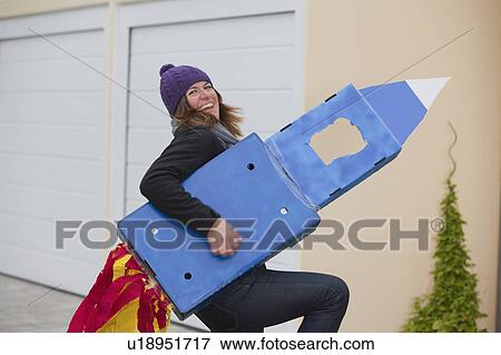 Stock Photo - Woman with selfmade rocket, smiling. Fotosearch