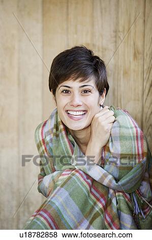 Stock Photo - Woman wrapped in a blanket in a hut. Fotosearch