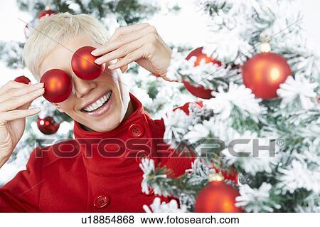 Woman's eyes behind christmas decoration View Large Photo Image Stock Photo - Woman's eyes behind christmas decoration. Fotosearch