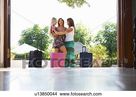 Picture - Women arriving at hotel with suitcases. Fotosearch
