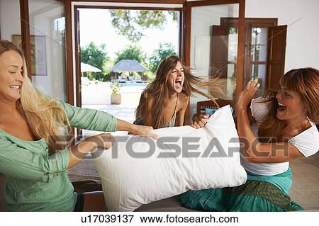 Women having pillow fight on hotel bed View Large Photo Image Stock Photo - Women having pillow fight on hotel bed. Fotosearch