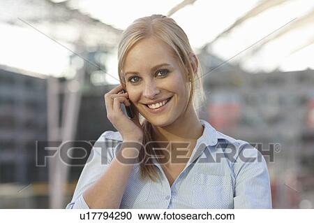 Stock Image - Women on cellphone smiling. Fotosearch