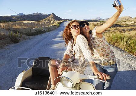 Women on motorbike taking photos View Large Photo Image Stock Image - Women on motorbike taking photos. Fotosearch