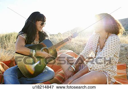 Women playing the guitar in the grass View Large Photo Image Stock Photo - Women playing the guitar in the grass. Fotosearch