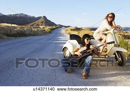 Women resting by road with motorbike View Large Photo Image Stock Image - Women resting by road with motorbike. Fotosearch