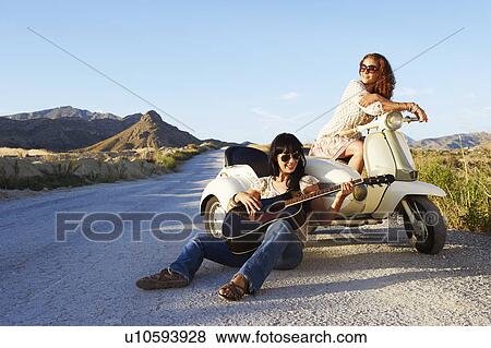 Women resting by road with motorbike View Large Photo Image Stock Photo - Women resting by road with motorbike. Fotosearch