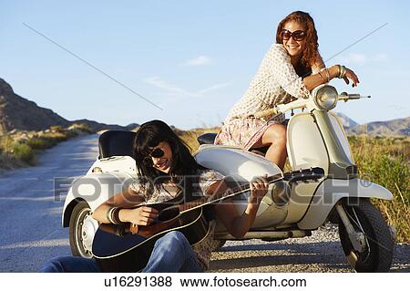 Women resting by road with motorbike View Large Photo Image Stock Photo - Women resting by road with motorbike. Fotosearch
