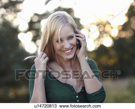 Women smiling with cellphone in nature View Large Photo Image Stock Image - Women smiling with cellphone in nature. Fotosearch