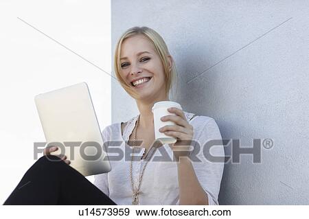Women smiling with coffee and ipad View Large Photo Image Stock Photo - Women smiling with coffee and ipad. Fotosearch