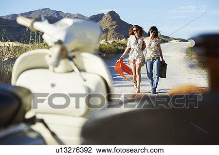 Women walking towards motorbike View Large Photo Image Stock Image - Women walking towards motorbike. Fotosearch