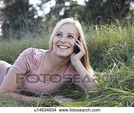 Picture - Women with cellphone in nature. Fotosearch
