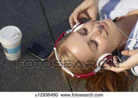 Stock Image - Women with headphone with in lunch break. Fotosearch