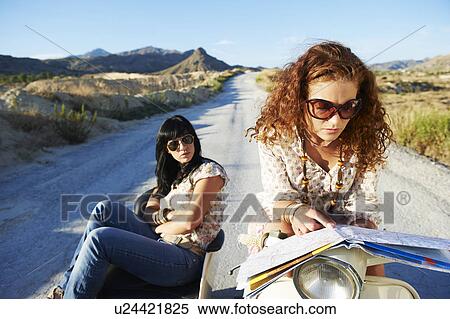 Women with motorbike looking at map View Large Photo Image Stock Photography - Women with motorbike looking at map. Fotosearch