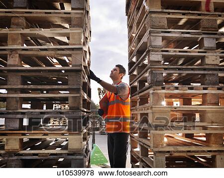 Stock Photo - Worker inspecting pallets. Fotosearch