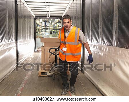 Stock Photo - Worker loads truck with pallet truck. Fotosearch