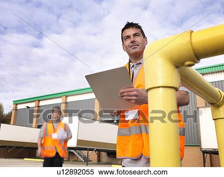 Workers in loading bay with clipboards View Large Photo Image Stock Photography - Workers in loading bay with clipboards. Fotosearch