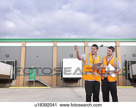 Stock Image - Workers in truck loading bay. Fotosearch