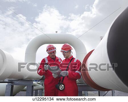 Picture - Workers with pipes at gas storage plant. Fotosearch