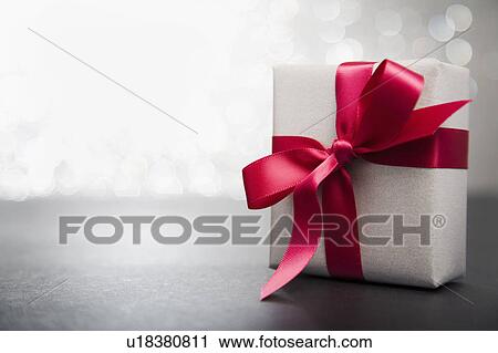 Stock Image - Wrapped gift with red ribbon. Fotosearch