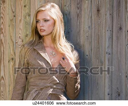 Stock Photograph - Young beautiful woman by wooden door. Fotosearch