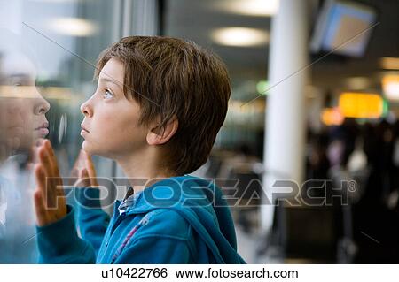 Young boy looking through a window View Large Photo Image Stock Photograph - Young boy looking through a window. Fotosearch