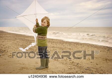 Young boy on beach holding kite. Fall View Large Photo Image Stock Photograph - Young boy on beach holding kite. Fall. Fotosearch
