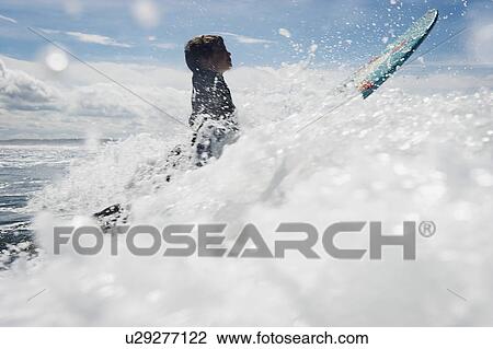 Young boy surfing through waves View Large Photo Image Stock Image - Young boy surfing through waves. Fotosearch