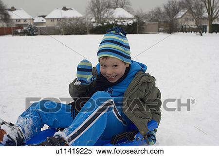 Young boy waving whilst on sledge View Large Photo Image Stock Photography - Young boy waving whilst on sledge. Fotosearch