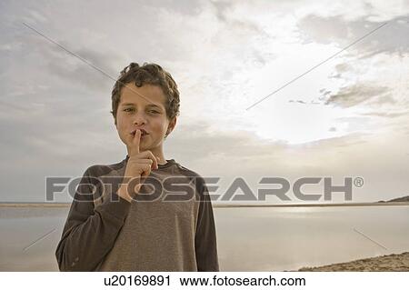 Young boy with finger to lips hushing View Large Photo Image Stock Image - Young boy with finger to lips hushing. Fotosearch
